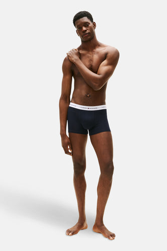 Blauwe boxershort van Tommy Jeans, gedragen door een getinte man op blote voeten.