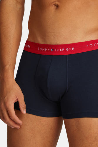 Blauwe boxershort van TOMMY JEANS, met rode band met logo, close-up.

