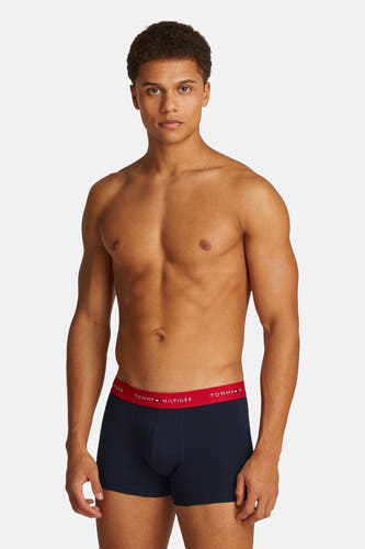 Blauwe boxershort van TOMMY JEANS, met een rode tailleband met logo en een strak model.
