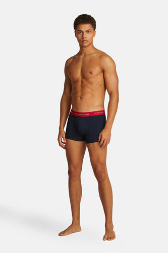 Blauwe boxershort van Tommy Jeans, gedragen door een man met een gespierd bovenlichaam.
