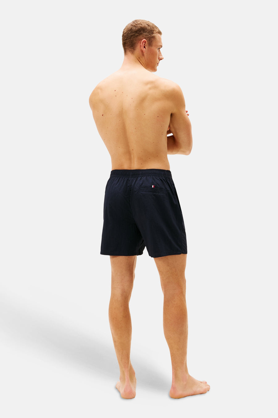Blauwe zwemshort van TOMMY JEANS, gezien van achteren, met een klein logo detail.