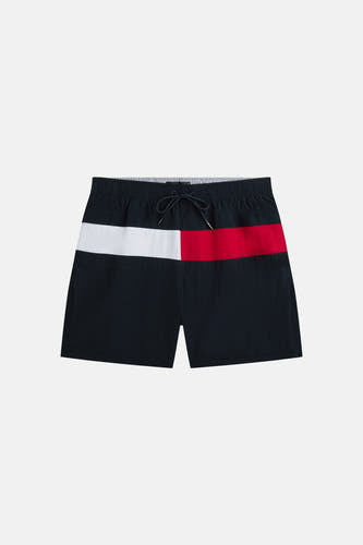 Blauwe zwemshort van TOMMY JEANS met rood en wit vlak bovenaan, en trekkoord in de taille.
