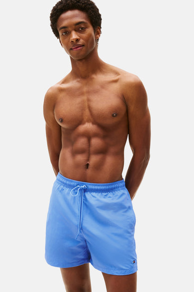 Blauwe zwemshort van Tommy Hilfiger, met trekkoord en logo op de pijp, gedragen door een model zonder shirt.