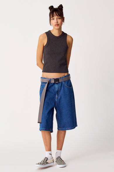 T-shirt noir Unwind, avec encolle et manches droites, associé à des short de denim larges et des baskets à carreaux.