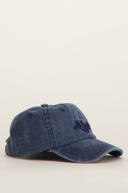 Blauwe pet van Unwind met een stonewashed effect en donkerblauwe borduursels.
