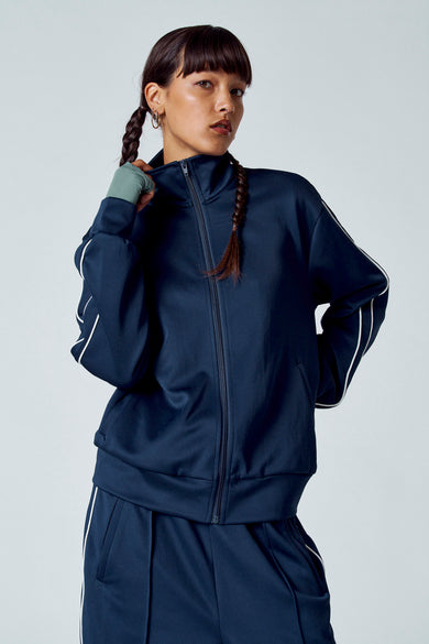 Blauw gilet met korte mouwen van Unwind, met witte strepen langs de mouwen, gedragen met een donkerblauwe broek.