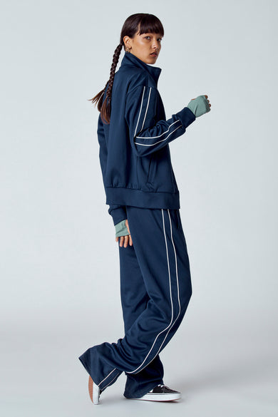 Blauw gilet met korte mouwen van Unwind, met een witte streep langs de zijkant en gedragen met sportkleding.
