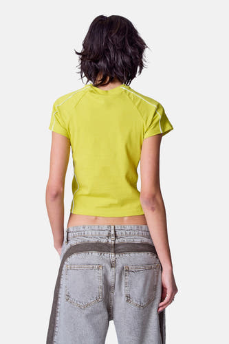 Groen T-shirt met korte mouwen van Unwind, met witte accenten en gedragen met een grijze jeans.