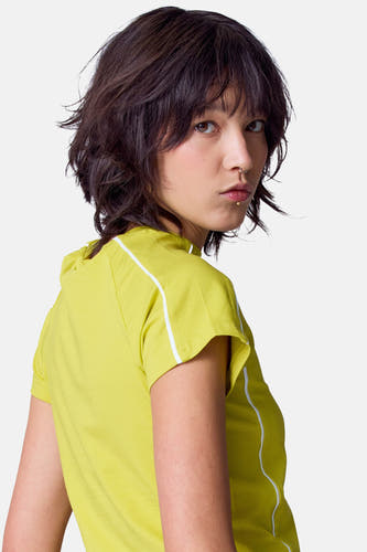 T-shirt vert avec manches courtes d'Unwind, avec une patte blanche le long de l'épaule et du côté.
