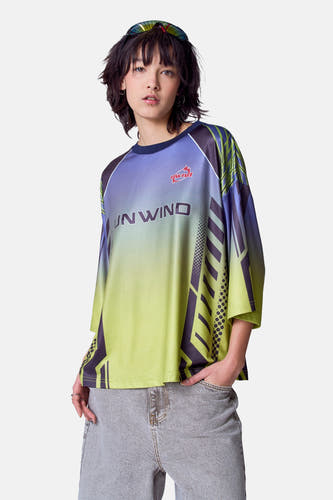 Groen T-shirt met korte mouwen van Unwind, met kleurverloop en geometrische patronen, gedragen met een grijze jeans.
