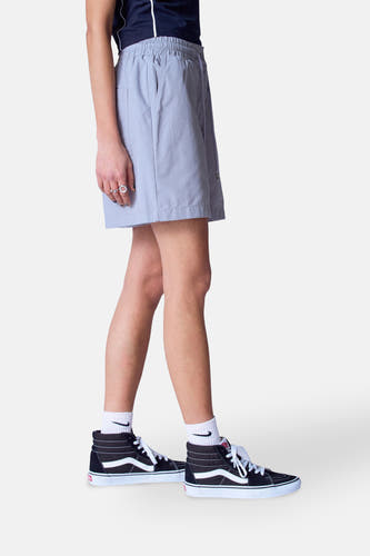 Grijze short van Unwind, met elastische tailleband en steekzakken, gedragen met hoge sneakers en witte sokken.
