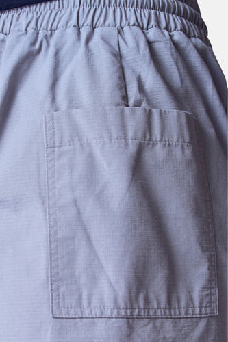 Grijze short van Unwind, met elastische tailleband en opgestikte zak, in close-up.
