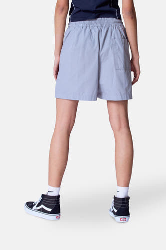 Grijze short van Unwind, gezien van achteren, gecombineerd met witte sokken en zwarte hoge sneakers.
