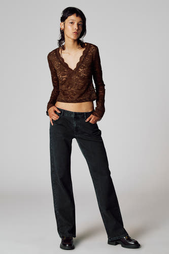 T-shirt marron à manches longues d'Unwind, avec des détails sur les bords, associé à un jeans foncé et des loafers.