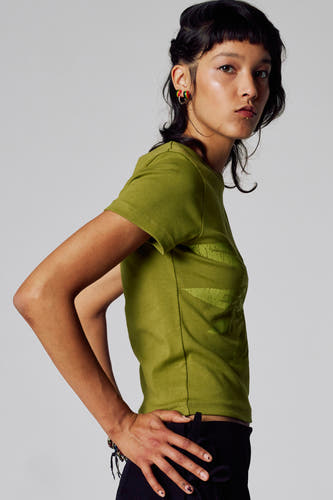 T-shirt vert avec manches courtes d'Unwind, imprimé et porté avec un pantalon noir.