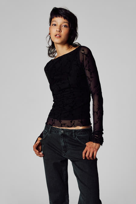T-shirt noir à manches longues d'Unwind, avec un motif floral et associé à un pantalon en corduroy.