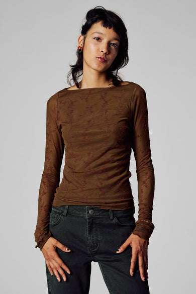 T-shirt marron à manches longues d'Unwind, avec un joli motif floral, associé à un pantalon foncé.