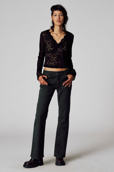 Zwart T-shirt met lange mouwen van Unwind, met kanten details en gedragen met donkere jeans en stoere schoenen.
