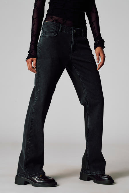 Grijze colorbroek van Unwind, met een losse pasvorm en gecombineerd met een doorschijnende top en zwarte loafers.
