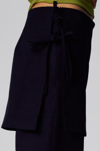 Pantalon noir Unwind, avec détail enroulé et fermeture éclair sur le côté.