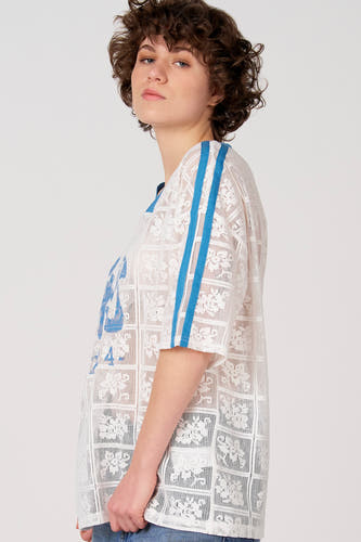 Wit T-shirt met korte mouwen van Unwind, met blauwe strepen op de schouders en kanten bloempatroon.