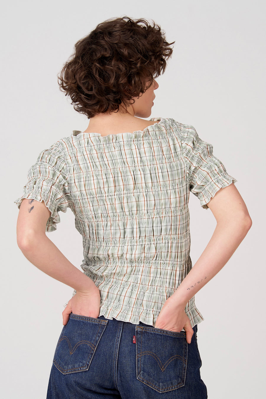 Groene blouse met korte mouwen van Unwind, met een ruitpatroon en geplooide details op een achterkantweergave.
