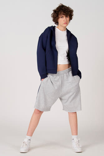 Blauw gilet van Unwind, gecombineerd met een wit T-shirt en grijze shorts.
