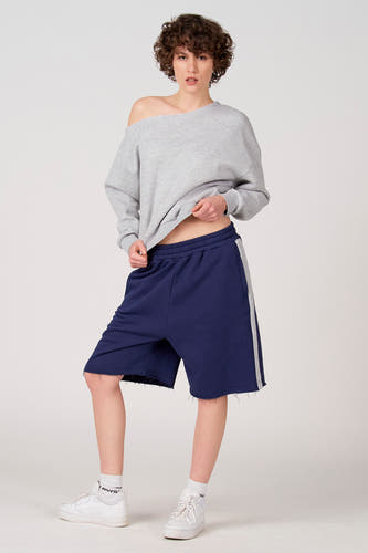 Short bleu d'Unwind avec une bande blanche sur le côté et un bord effiloché.