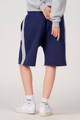 Blauwe short van Unwind met grijze streep aan de zijkant en gerafelde rand, achterzijde.