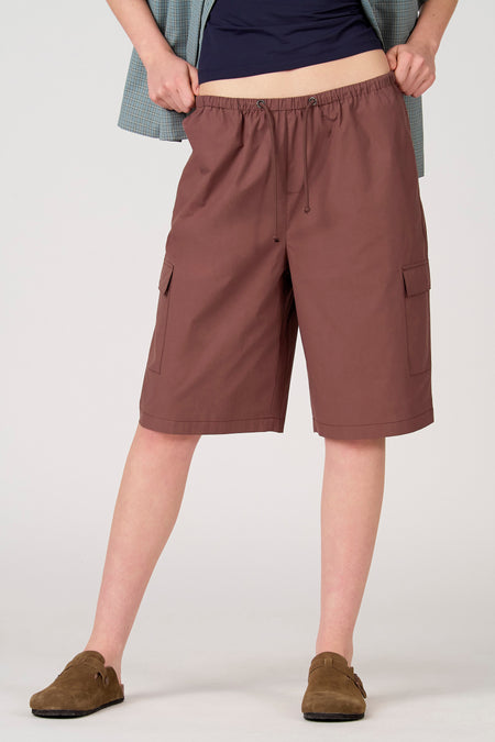 Short marron Unwind avec taille à cordon de serrage et poches à rabat latérales, porté par un mannequin.