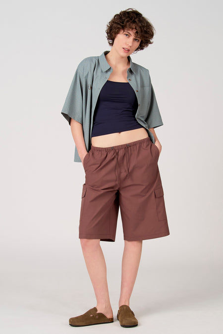 Short marron Unwind avec poches cargo et taille à cordon de serrage, stylisé avec une chemise à carreaux et des mules en daim.