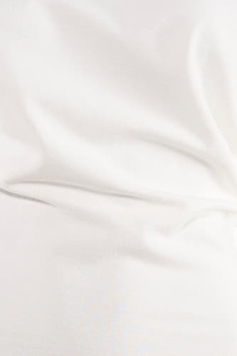 T-shirt blanc Unwind avec texture douce et légers plis.