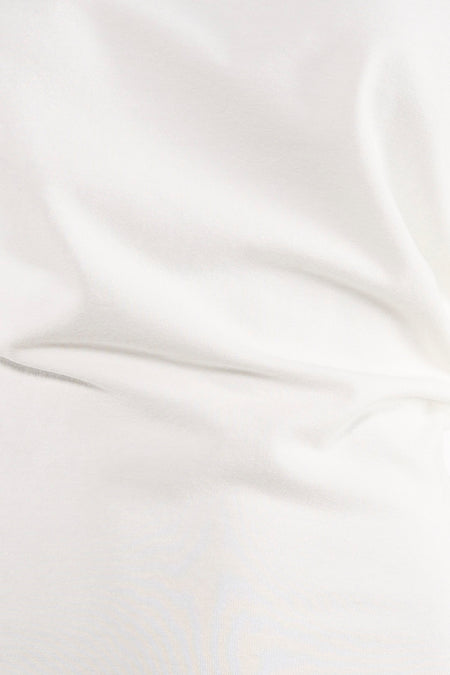 T-shirt blanc Unwind avec texture douce et légers plis.