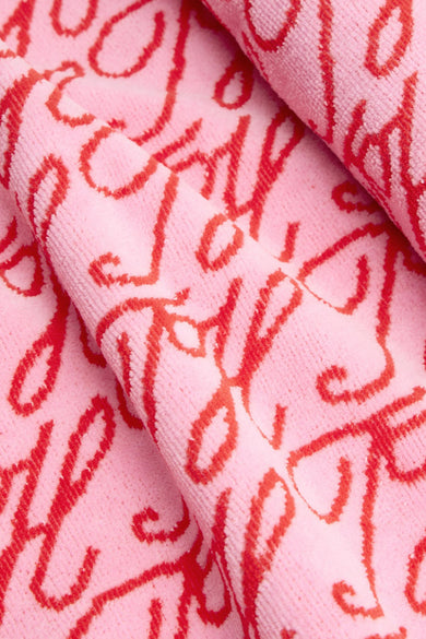 Roze badstof strandkleding van TOMMY JEANS met een herhalend patroon van rode 'Joy'-letters en een zachte textuur.
