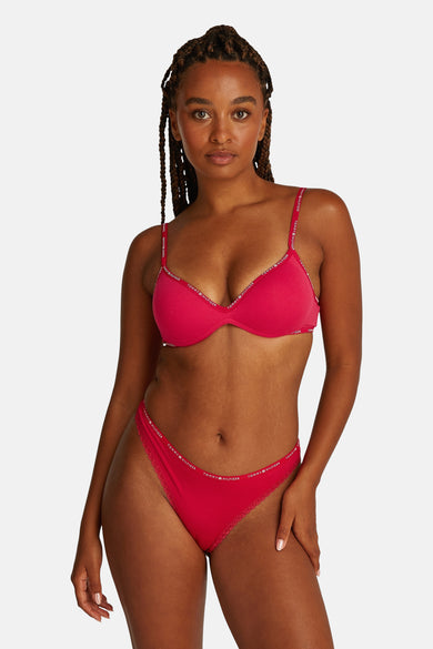 Roze beha van Tommy Jeans, met logo-details langs de bandjes, gedragen door een model.
