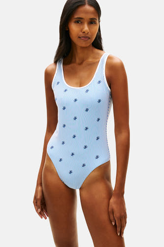 Blauw-wit gestreept badpak van TOMMY JEANS met geborduurde, kleine logo's, gedragen door een model.