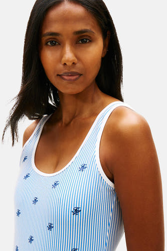 Blauw gestreept badpak van TOMMY JEANS met geborduurde initialen, gedragen door een model.