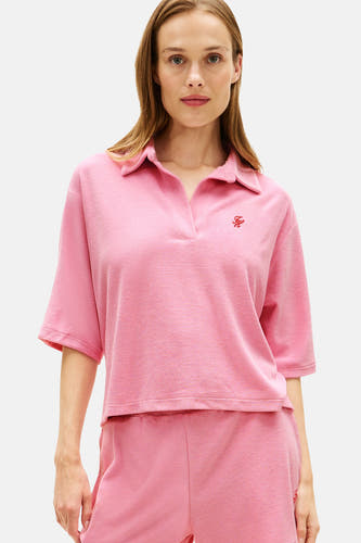 Roze polo met korte mouwen van TOMMY JEANS van badstof met V-hals en geborduurd rood logo.