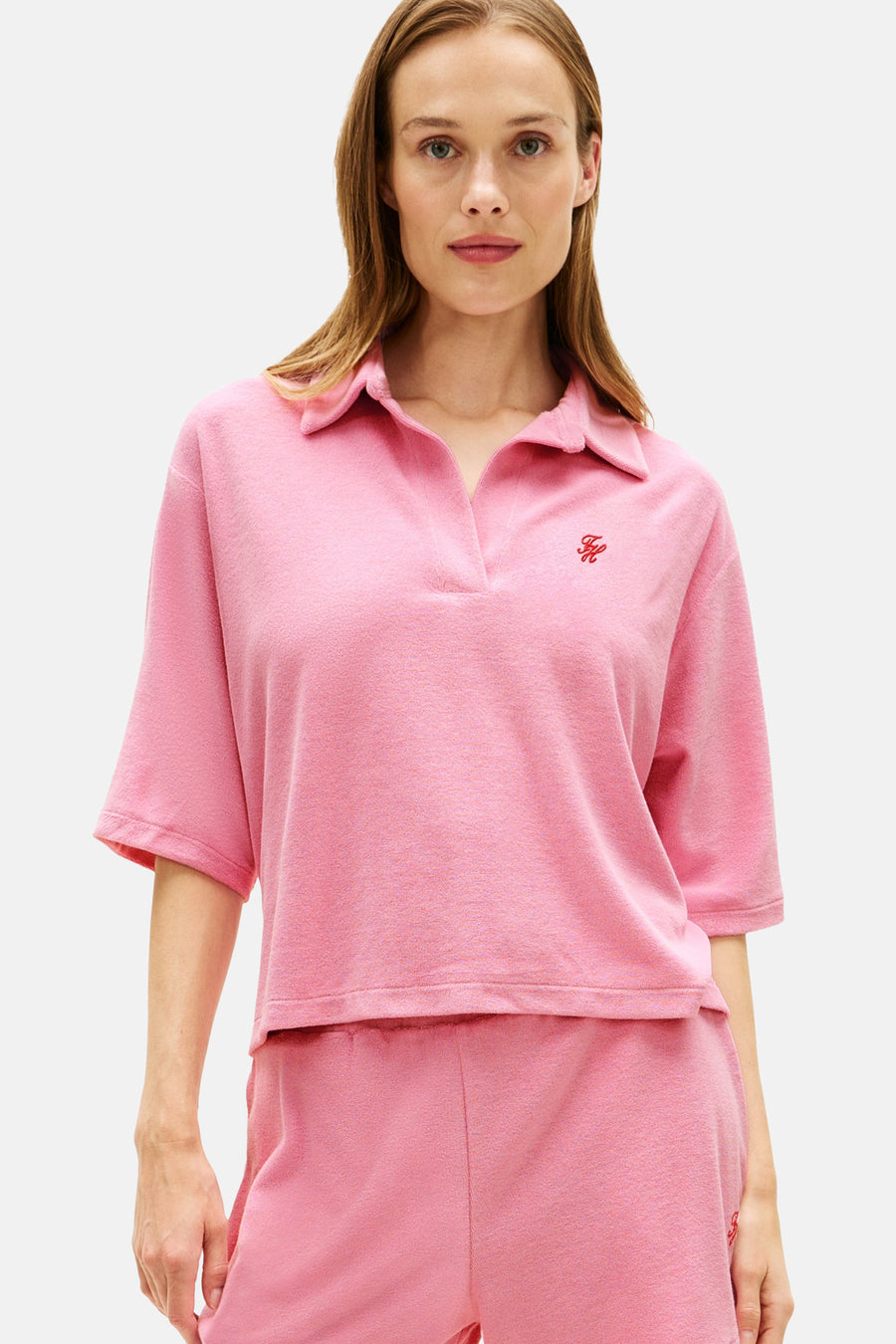 Roze polo met korte mouwen van TOMMY JEANS van badstof met V-hals en geborduurd rood logo.