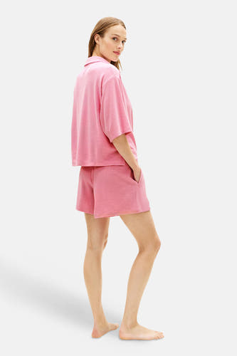Roze polo met korte mouwen van TOMMY JEANS, in melange stof, gedragen door model met bijpassende shorts.