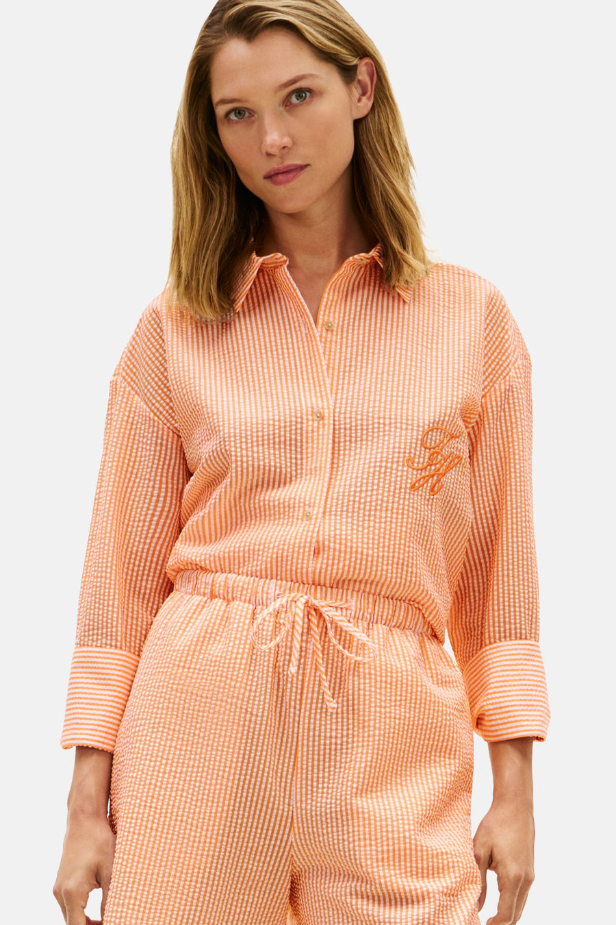 Oranje gestreept hemd met lange mouwen van TOMMY JEANS, met een seersucker textuur en geborduurd logo op de borst.