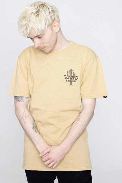 T-shirt beige à manches courtes de VANS avec logo cactus et texte "Since 1966", porté par un mannequin dans une photo lifestyle