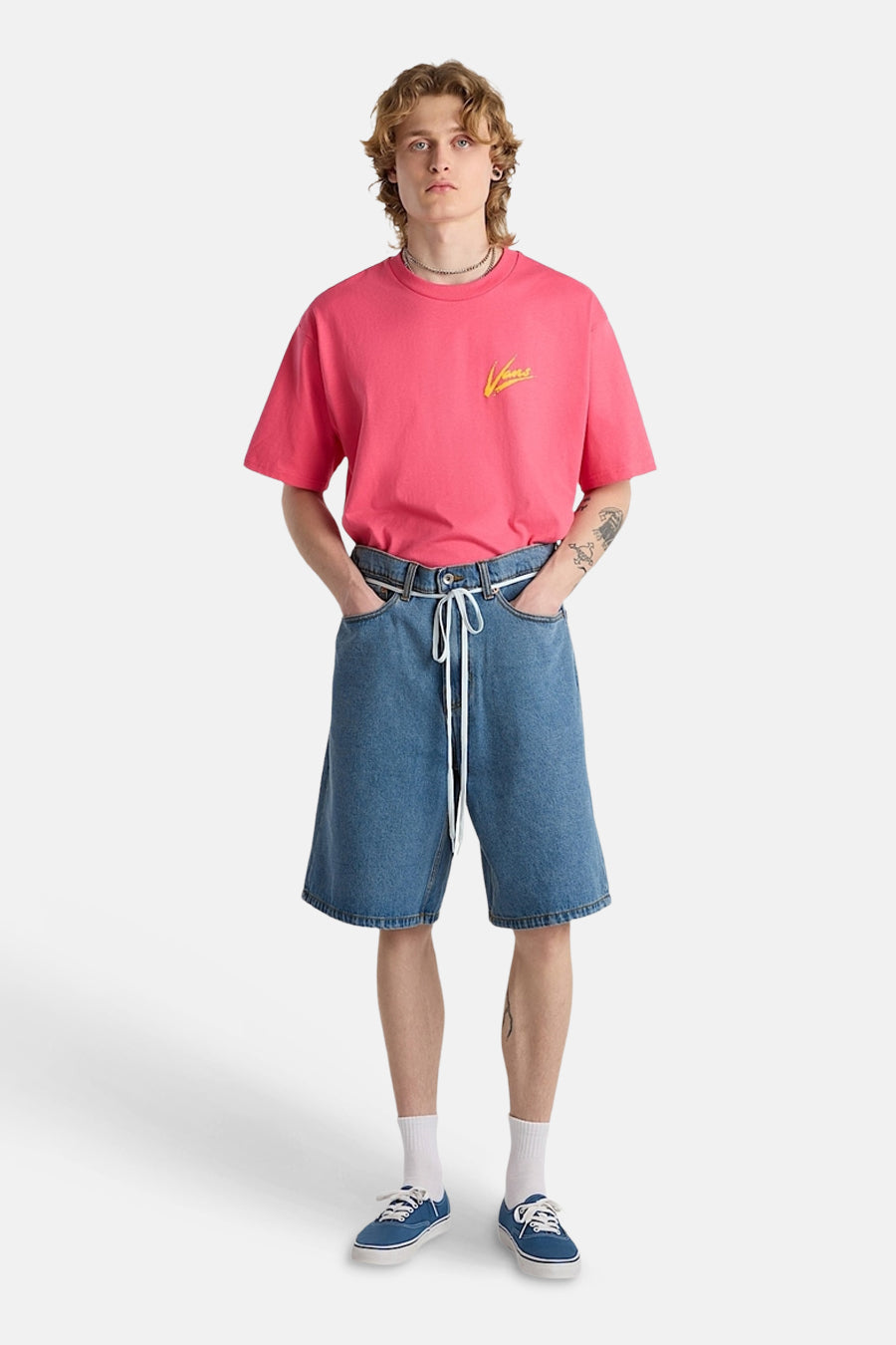 Short en jean bleu clair de VANS avec un cordon de serrage blanc, porté avec un t-shirt rose.