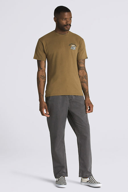 T-shirt beige à manches courtes de VANS avec petit logo sur la poitrine, porté avec un jean gris et des baskets à damier, vue de face.