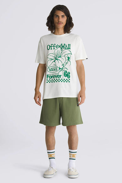Ecru T-shirt van VANS “OFF THE WALL” met groene bloemenprint, gecombineerd met groene shorts en crèmekleurige sneakers.
