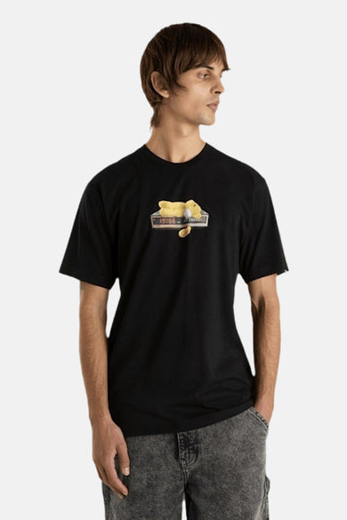 Zwart T-shirt met korte mouwen van VANS “OFF THE WALL” met cartoonprint op de borst, gedragen met grijze jeans.
