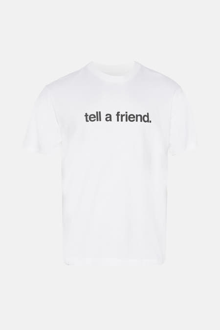 Wit T-shirt met korte mouwen van VANS “OFF THE WALL” met de tekst "tell a friend" erop gedrukt, gefotografeerd van voren.