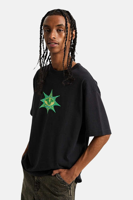 Zwart T-shirt met korte mouwen van VANS “OFF THE WALL”, met een groene print op de borst.
