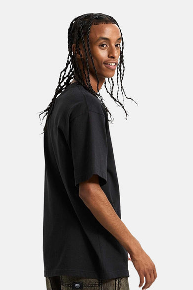 T-shirt noir à manches courtes de Vans, avec un col rond et porté par un modèle.
