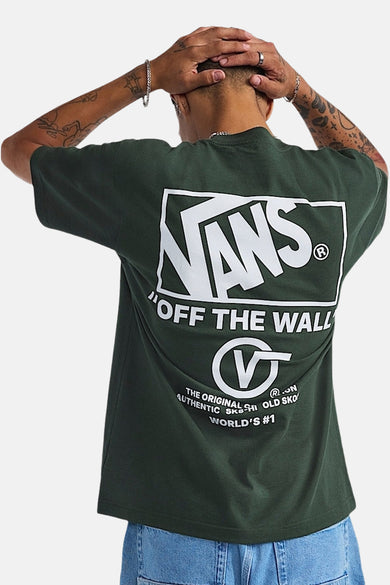 T-shirt vert avec manches courtes de VANS "OFF THE WALL", avec logo et impression de texte sur la poitrine, porté avec des bagues et des bracelets.